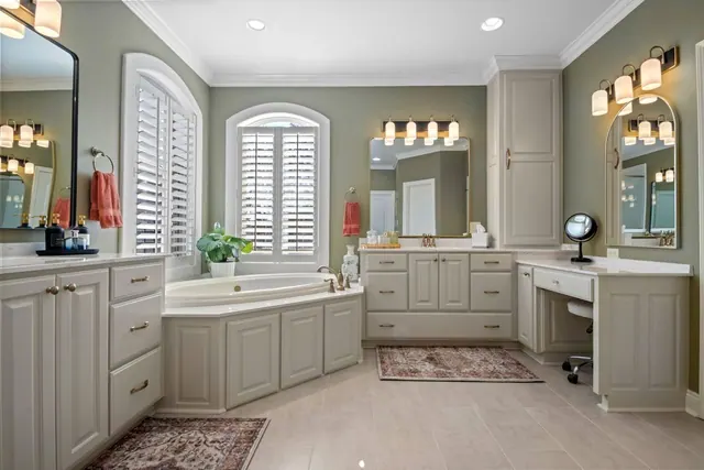 Primary bath with double vanities, a soaking tub and an arched window