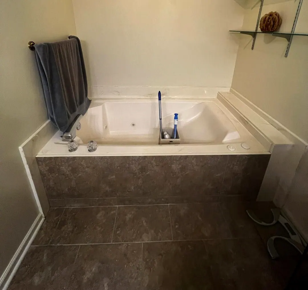 Before: Dated garden tub on a tiled deck before the remodel