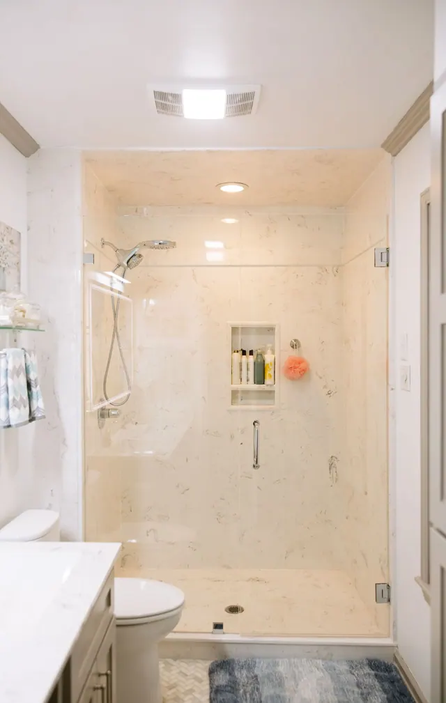 Walk-in shower with stone-look walls, a long niche and glass door