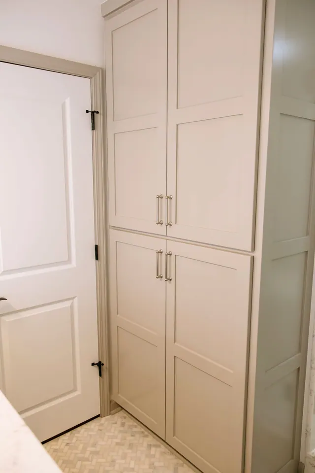 Floor-to-ceiling linen cabinet painted in soft greige