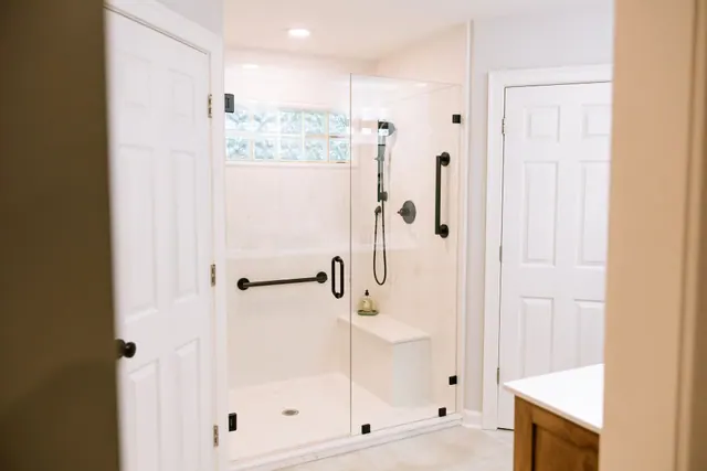 Bright walk-in shower seen through the bathroom doorway