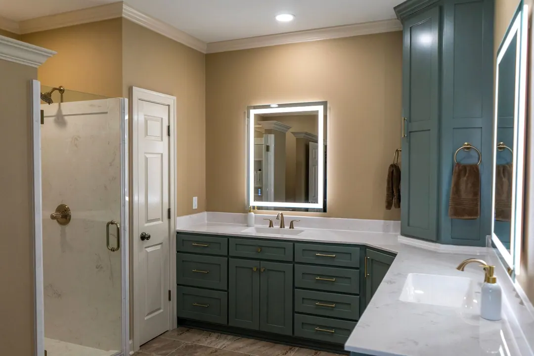 Bathroom with teal shaker cabinets, a backlit mirror, quartz tops and a glass shower