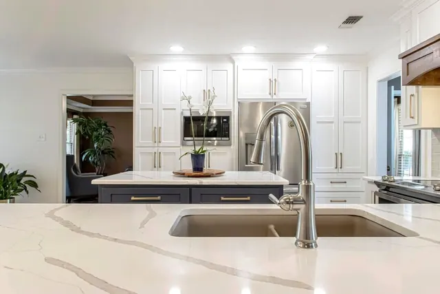 Veined quartz island with an undermount sink and arched faucet