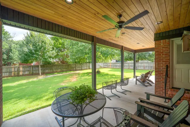 Covered patio with a cedar ceiling, ceiling fan and a view of the yard