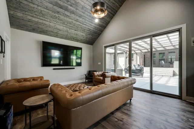 Entertainment room with leather sofas and sliding doors to a covered patio