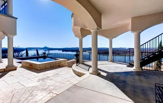 Columned patio and hot tub above a lake view